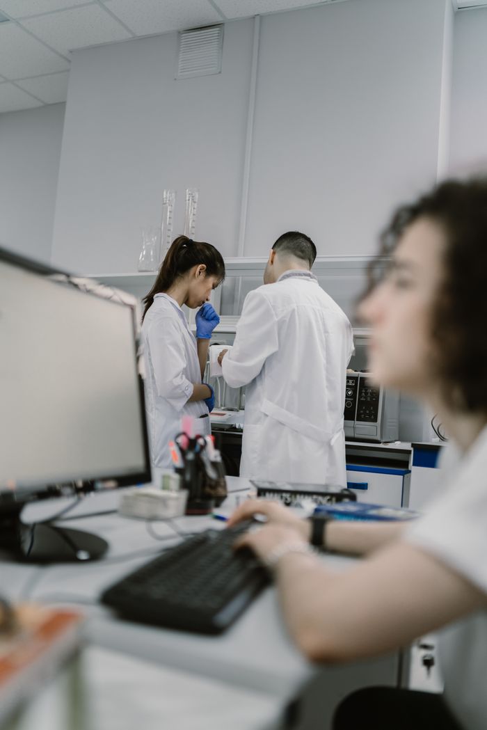 Scientists collaborating in a modern laboratory setting with computers and lab equipment.
